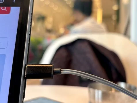 Close up of a charging cable plugged into a tablet or laptop. Stock Photos