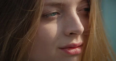 Close up of Charming Woman's Face with Sunbeams looking ahead while Wind Blows Stock Footage 158814358