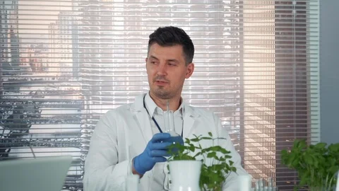 Close-up of cheerful scientist in lab coat making cheers with his colleagues of Stock Footage 115254171