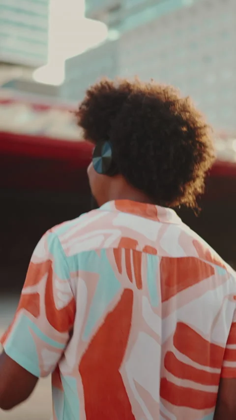 Close-up of cheerful young African American man wearing shirt listening to music Stock Footage 227004553