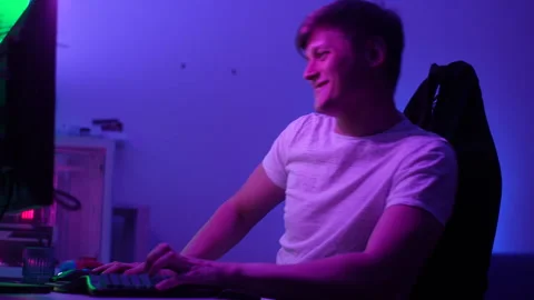Close-up cheerful young man playing online computer video game, colorful Video stock 250260980