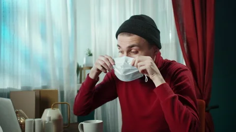 Close-up of cheerful young man taking on protective mask. Portrait of smiling Stock Footage 151332061
