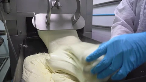 Close-up of cheese flow out from a machine in factory Stock Footage 129928203
