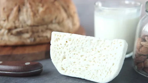 Close up of cheese, milk , brown bread and almond nut on table. Stock Footage