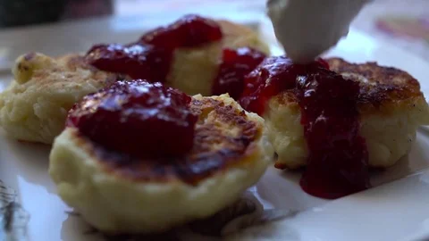 Close-up cheese pancakes with berry jam and sour cream. Slow Motion. HD Stock-Footage 71645488