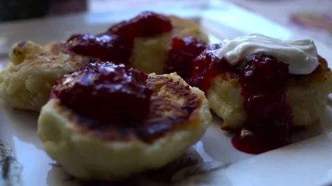 Close-up cheese pancakes with berry jam and sour cream. Slow Motion. HD Video stock 71755100