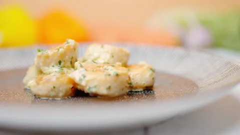 Close-up of a chef adding cream sauce on top of the scallops in a serving plate. Stock Footage 138068130