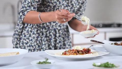 Close-up of Chef Adding Grated Mozzarella Cheese Topping to a Tortilla Wrap Stock-Footage 334915474