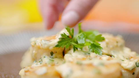 Close-up of a chef adding greens on top of the scallops in a serving plate. Stock Footage 138068154