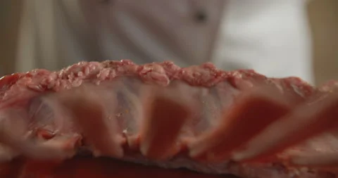 Close-up chef adds spices to fresh beef ribs. 4K slow motion video Stock Footage 103861099