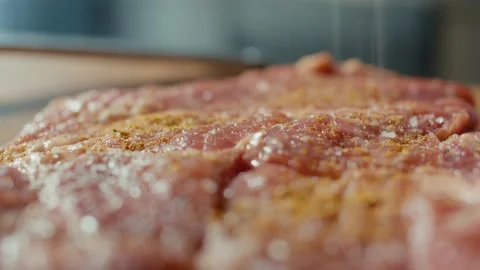 Close up of Chef Applying Grained Salt on Raw Piece of Steak. Cooking Pork Chops Stock Footage 196257760