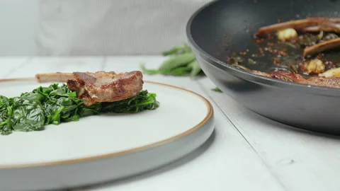 Close-up Chef arranging nicely cooked lamb ribs cutlets into serving plate in 4K Stock Footage 146000953