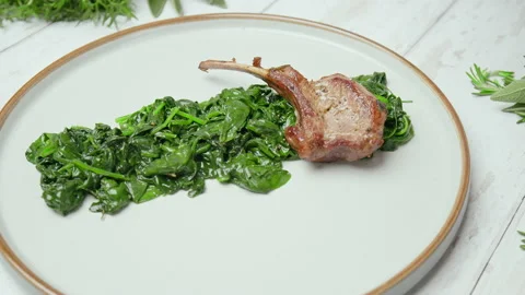 Close-up Chef arranging nicely cooked lamb ribs cutlets into serving plate in 4K Stock Footage 146001069