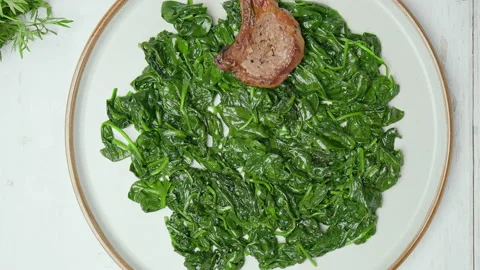 Close-up Chef arranging nicely cooked lamb ribs cutlets into serving plate in 4K Stock Footage 146001556