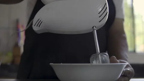 Close up chef beating eggs with an electric mixer on a gray kitchen counter Stock Footage 272496481