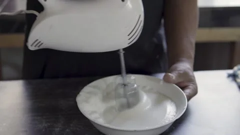 Close up chef beating eggs with an electric mixer on a gray kitchen counter Stock Footage 272496867