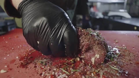 Close-up of a chef in black gloves marinating raw meat. Stock Footage 234180421