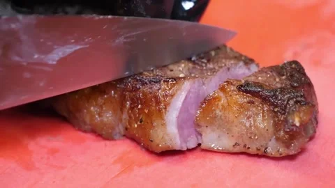 Close-Up of Chef in Black Gloves Slicing Juicy Grilled BBQ Steak on Red Surface Stock Footage 332815215
