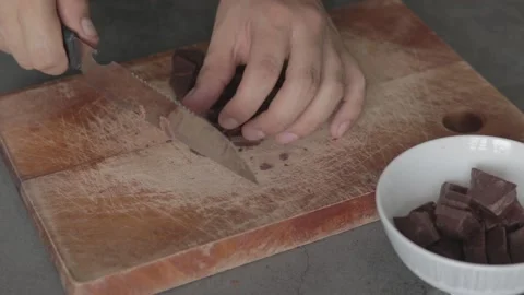A Close up of a chef chopping a bar of chocolate on a wooden table. Slow moti Stock Footage 139321567