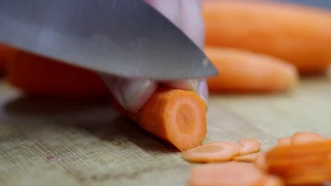 Close-up of chef chopping a carrot with red pepper on cutting board. Stock Footage 70759627
