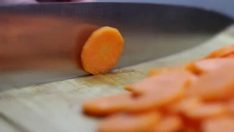 Close-up of chef chopping a carrot with red pepper on cutting board. 動画素材 70759696