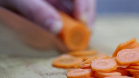Close-up of chef chopping a carrot with red pepper on cutting board. Stock Footage 70759846