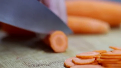 Close-up of chef chopping a carrot with red pepper on cutting board. Stock Footage 70759998