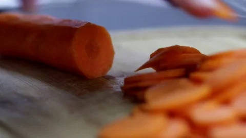Close-up of chef chopping a carrot with red pepper on cutting board. Stock Footage 70760176