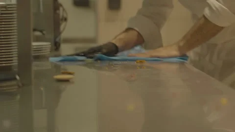 Close-up chef cleaning metal work surface with wipe Stock Footage 336173840