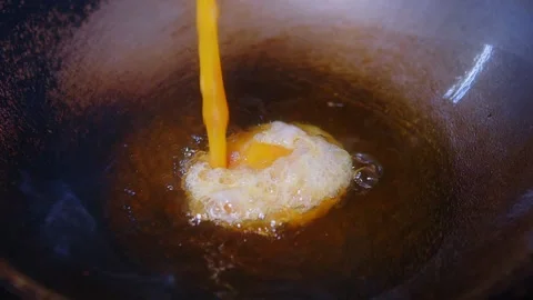 Close up chef cooking pouring Thai style food fried omelette or omelet in hot oi Stock Footage 194468887
