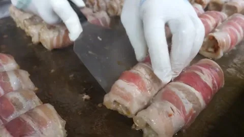 Close-Up of Chef Cooking Traditional Bacon Wrapped Kimchi Pork Rolls on Street F Video stock 343588046