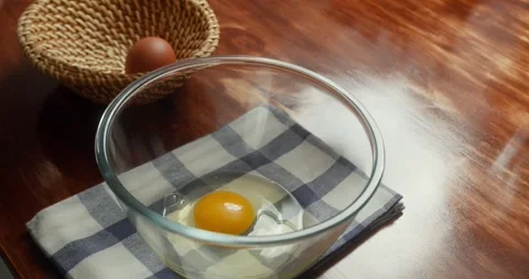 Close-up of chef cracking fresh eggs into a glass bowl in kitchen cooking Stock Footage 319381857
