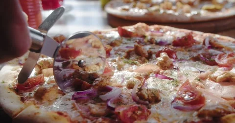 Close-up of chef cuts delicious pizza with round knife Stock Footage 148765836