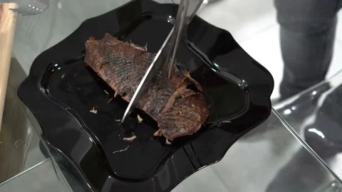 Close-up, the chef cuts a piece of roast duck with a large kitchen knife  Video stock 125397815