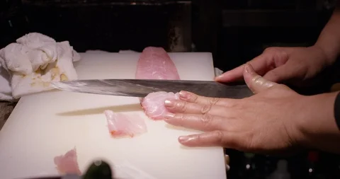 Close up of chef cutting and slicing fish fillet in slow motion, Japan Stock Footage 124708314