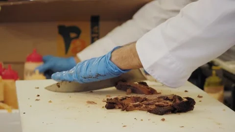 Close up of chef cutting baked beef into slices with knife on cutting board Stock Footage 221861681