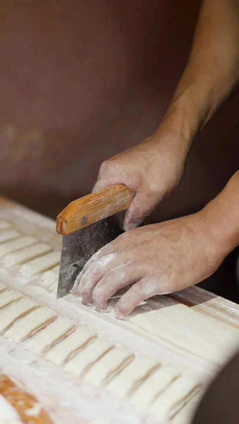 Close Up of Chef Cutting Dough into Small Strips with Bench Scraper Stock Footage 339870813