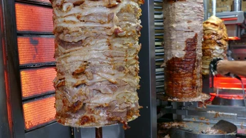 Close-up of a chef cutting juicy roasted meat, making traditional Greek gyros Stock Footage 283374810