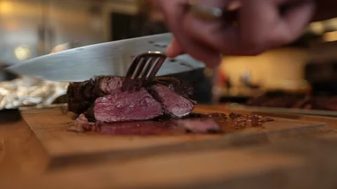 Close up on chef cutting medium rare steak to serve for dinner Stock Footage 90828339