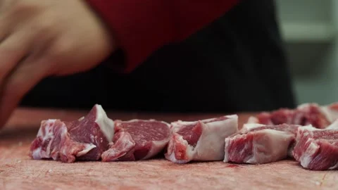 Close-Up of Chef Cutting Raw Lamb Chops on a Cutting Board Stock-Footage 328782855