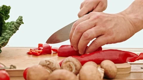 Close-up of a chef cutting red bell peppers on a kitchen table. 스톡 동영상 232699509