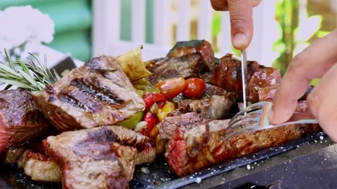 Close up of chef cutting steak on variety meat platter at outdoor Argentine pari Video stock 345094865