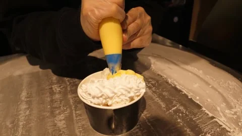Close-up of Chef Decorating Thai Rolled Ice Cream with Whipped Cream and Mango S Stock Footage 345293092
