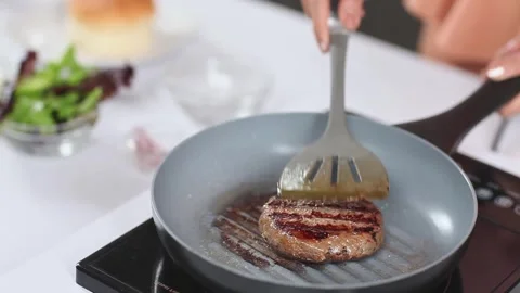 Close-up of Chef Flipping a Grilled Burger Patty in a Frying Pan 스톡 동영상 336536649