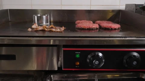 Close-up of the chef frying bacon on a large stove in the restaurant kitchen. Video stock 342702551