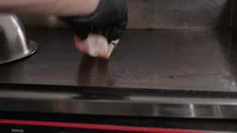 Close-up of the chef frying bacon on a large stove in the restaurant kitchen. Stock Footage 344038358