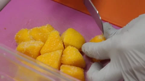 Close-Up of Chef in Gloves Cutting Fresh Ripe Mango on Pink Board 스톡 동영상 345659221