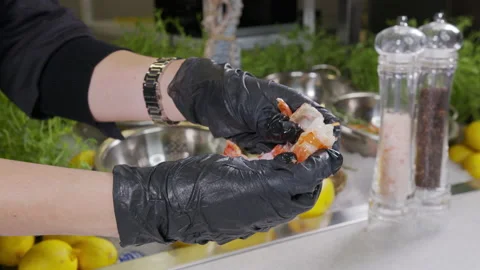 Close-up of a chef in gloves peels a shrimp in the restaurant kitchen, cooking a Stock Footage 144733790