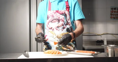 Close-up of a chef in gloves preparing a dish of salmon slices and daikon salad Stock Footage 134274747