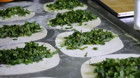 Close-up of a chef in gloves preparing tortillas with herbs, kutabs, gozleme. Stock Footage 320877742